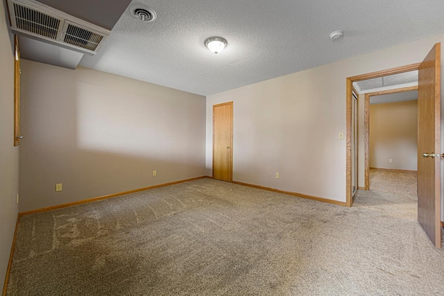 unfurnished room featuring visible vents, carpet flooring, a textured ceiling, and baseboards