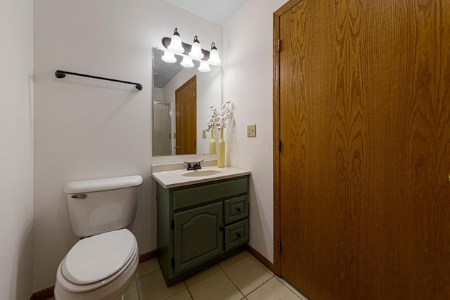 bathroom featuring baseboards, toilet, vanity, and tile patterned flooring