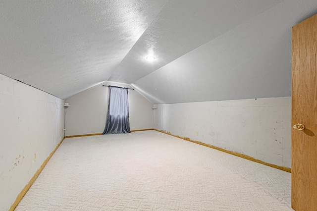 bonus room with baseboards, carpet floors, a textured ceiling, and lofted ceiling