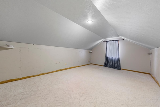 bonus room with lofted ceiling, carpet floors, and a textured ceiling