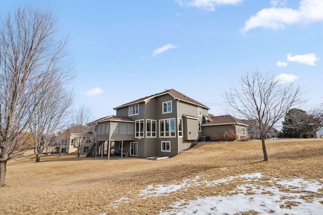 back of house with stairs and a sunroom