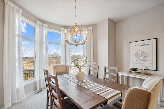 dining room featuring visible vents, baseboards, carpet, and a chandelier