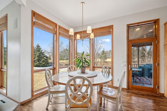 dining space with visible vents, baseboards, an inviting chandelier, and wood finished floors