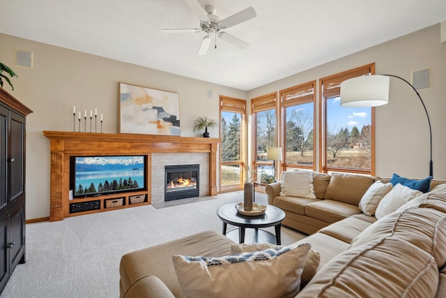 living room with visible vents, baseboards, carpet, a fireplace, and a ceiling fan