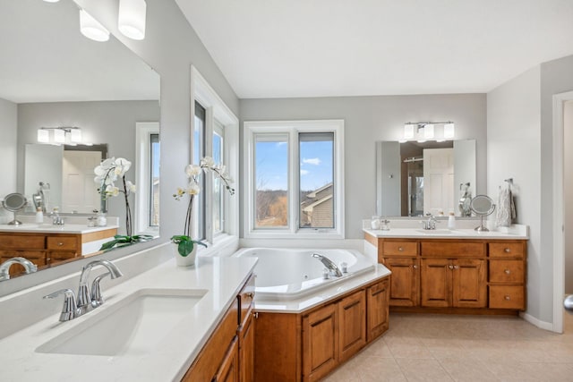 bathroom with a sink, a tub with jets, a shower stall, and tile patterned flooring