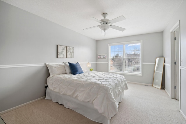 bedroom featuring ceiling fan, baseboards, and light carpet