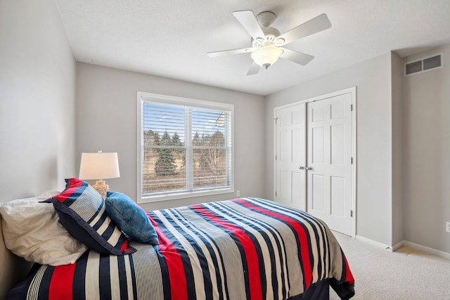 bedroom with visible vents, a closet, carpet flooring, baseboards, and ceiling fan