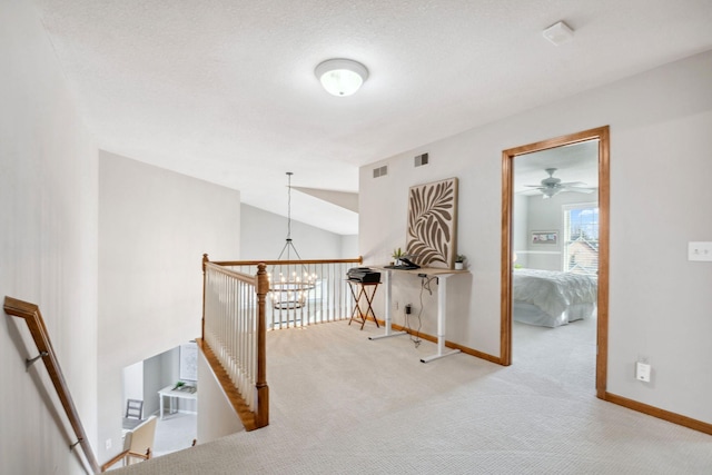 corridor with an inviting chandelier, carpet, visible vents, and baseboards