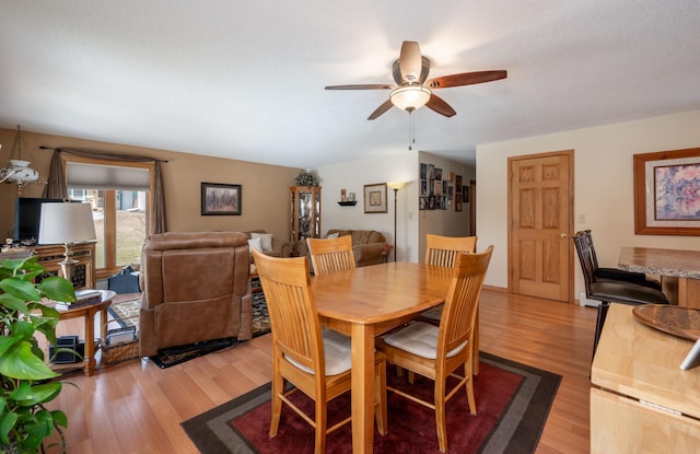 dining room with a ceiling fan, light wood-type flooring, and a textured ceiling