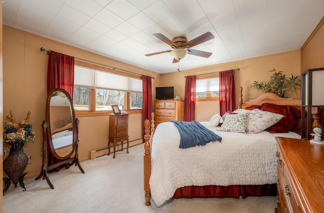 bedroom featuring a baseboard radiator, multiple windows, light carpet, and ceiling fan