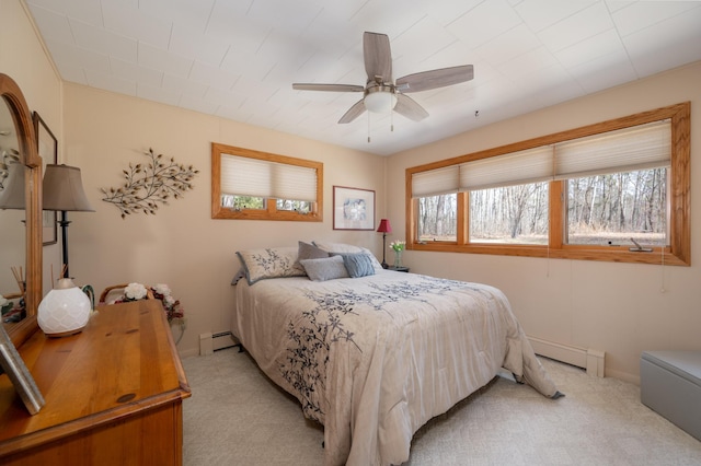 bedroom with a baseboard heating unit, light colored carpet, and a ceiling fan