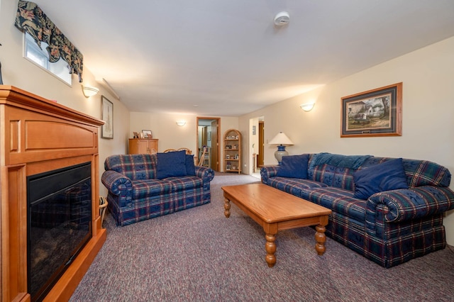 carpeted living room featuring a glass covered fireplace