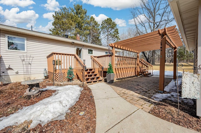 back of property with a wooden deck, a pergola, and a patio