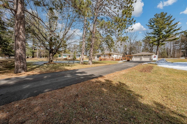 view of front of home with a front yard, a garage, and driveway