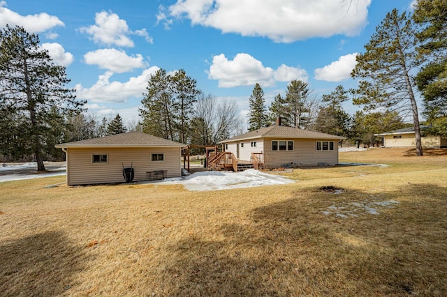 back of property with a yard and a deck