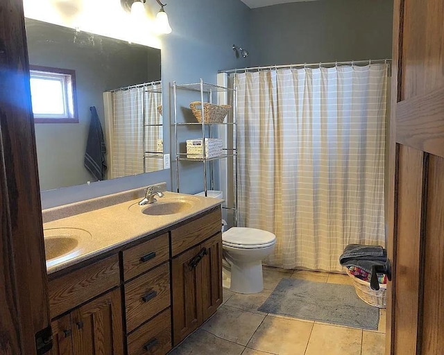 full bathroom featuring tile patterned floors, a shower with curtain, toilet, a sink, and double vanity