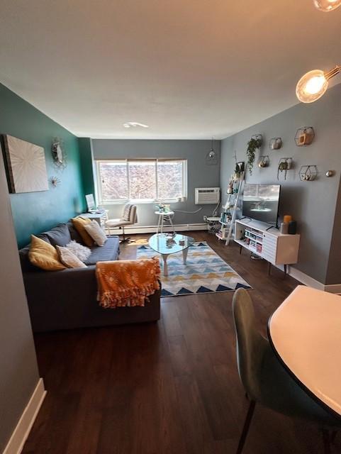 living room with baseboards, wood finished floors, and a wall mounted AC