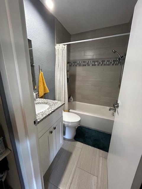 full bathroom with toilet, shower / tub combo with curtain, and vanity