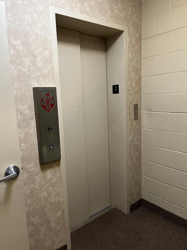 room details featuring elevator and concrete block wall