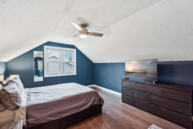 bedroom featuring baseboards, lofted ceiling, wood finished floors, a textured ceiling, and a ceiling fan