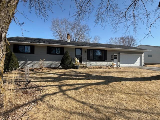 ranch-style home with a garage, driveway, and a chimney