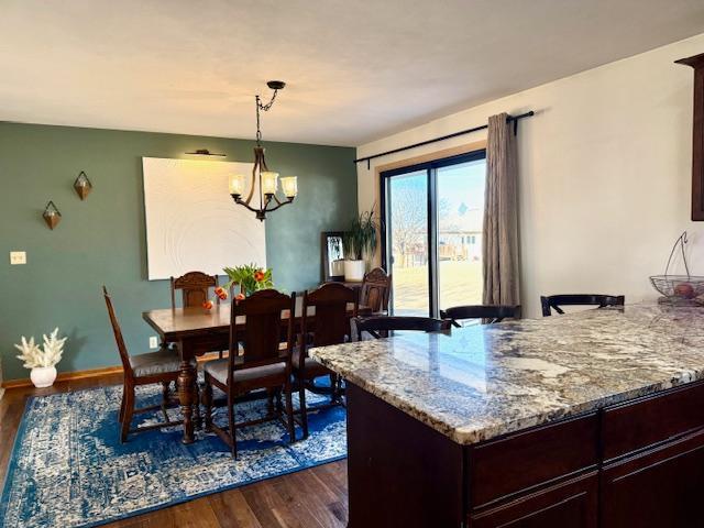 dining room with baseboards, an inviting chandelier, and dark wood finished floors