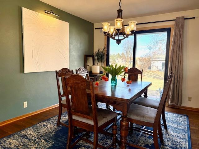 dining room featuring baseboards, a notable chandelier, and wood finished floors