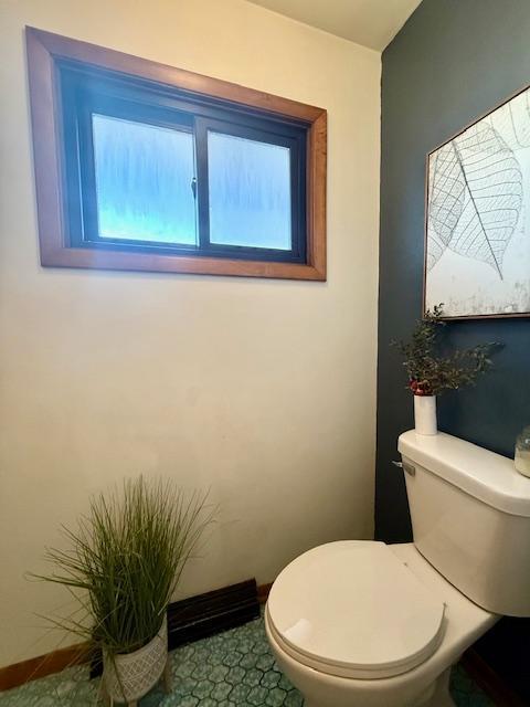 bathroom with toilet and baseboards