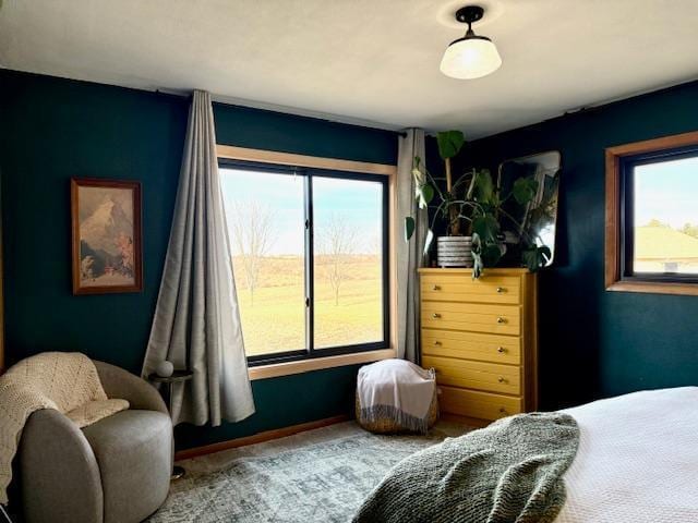 carpeted bedroom with multiple windows and baseboards