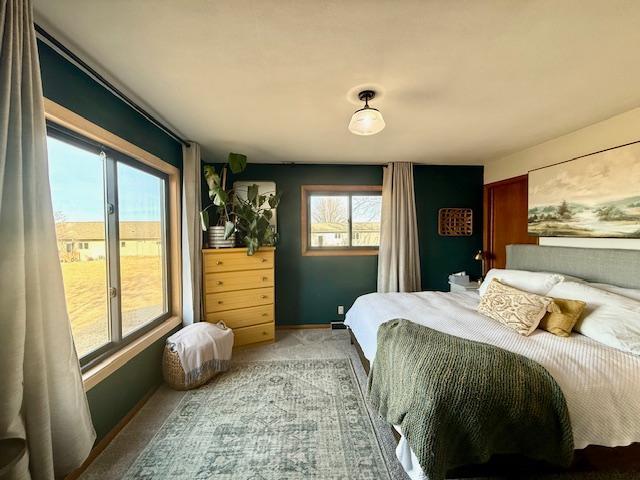 bedroom featuring baseboards and light colored carpet