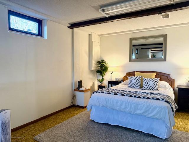 carpeted bedroom with visible vents and baseboards