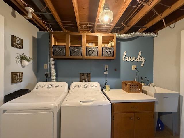 laundry area featuring a sink, cabinet space, and separate washer and dryer