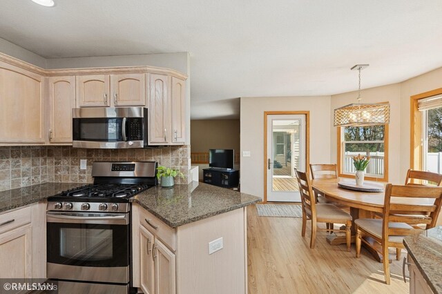 28942 Dawson Ave, Randolph, MN 55065 - kitchen featuring appliances with stainless steel finishes, tasteful backsplash, light wood-style flooring, light brown cabinets, and dark stone counters