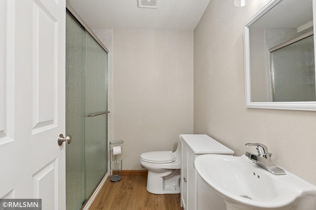 28942 Dawson Ave, Randolph, MN 55065 - bathroom with a sink, wood finished floors, a shower stall, and toilet