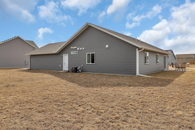 view of side of property featuring cooling unit, a patio, and a yard