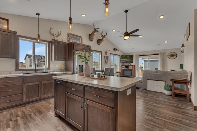 kitchen with light countertops, open floor plan, dark wood-style flooring, and a sink