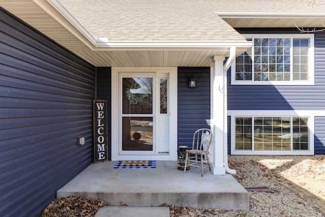 property entrance featuring a porch and a shingled roof