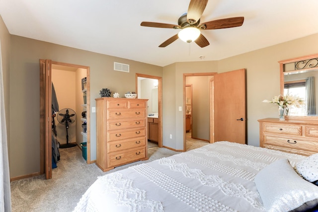 bedroom with a spacious closet, light colored carpet, visible vents, and a closet