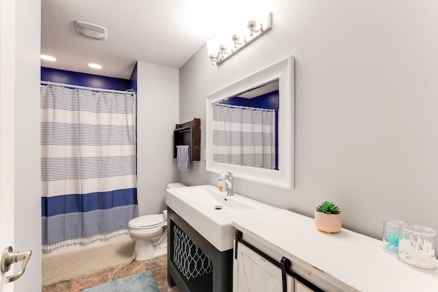 bathroom with a shower with curtain, toilet, vanity, and stone finish flooring