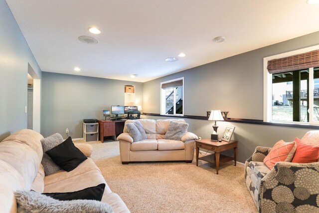 living room with recessed lighting, light colored carpet, and baseboards