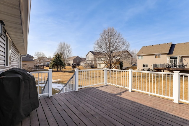 wooden deck with a residential view and a grill