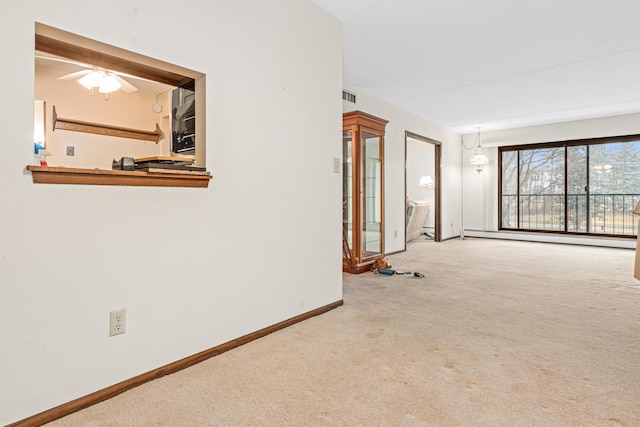 carpeted empty room with a baseboard heating unit, visible vents, and baseboards