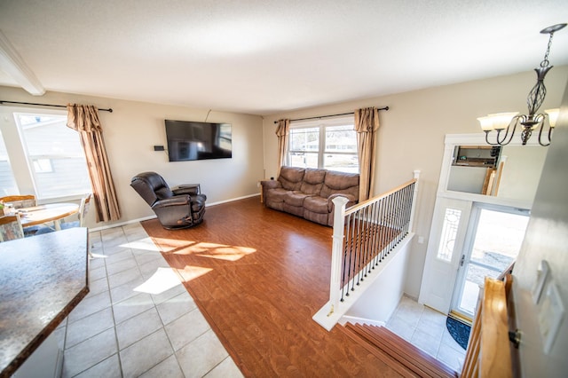 living room with light wood-type flooring, baseboards, and a chandelier