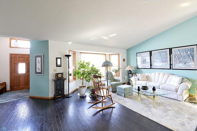 living area featuring a textured ceiling, hardwood / wood-style flooring, baseboards, and vaulted ceiling