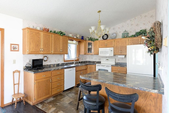 kitchen featuring a sink, a kitchen breakfast bar, white appliances, wallpapered walls, and vaulted ceiling