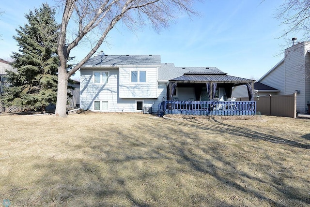 rear view of property featuring a lawn