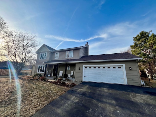 traditional-style house featuring aphalt driveway, a porch, fence, a garage, and a chimney