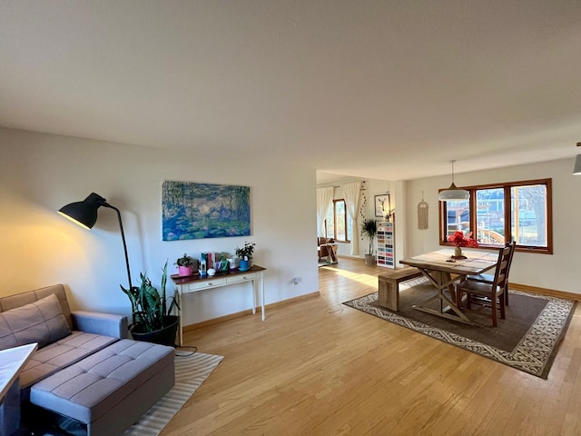 dining room featuring a wealth of natural light, baseboards, and light wood-style flooring