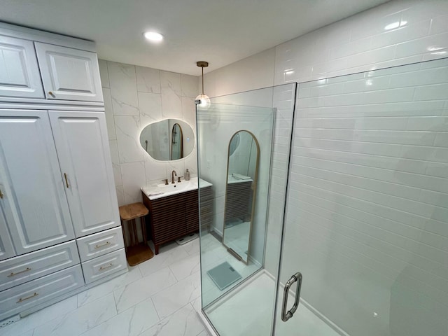 full bathroom with vanity, recessed lighting, an enclosed shower, marble finish floor, and tile walls