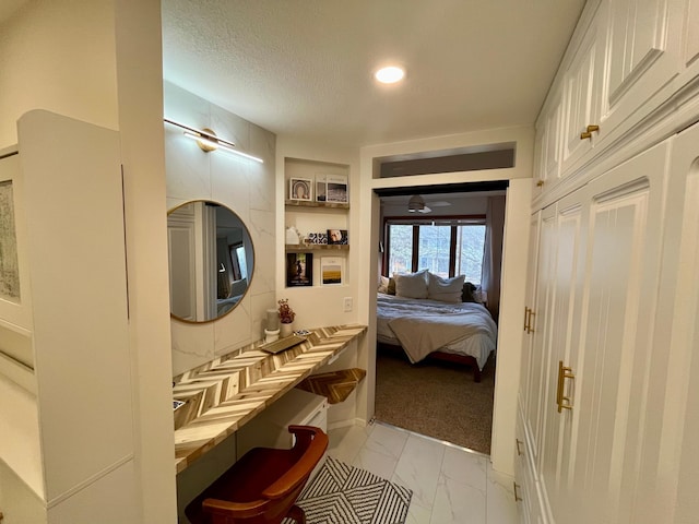 bathroom featuring connected bathroom, a textured ceiling, and marble finish floor